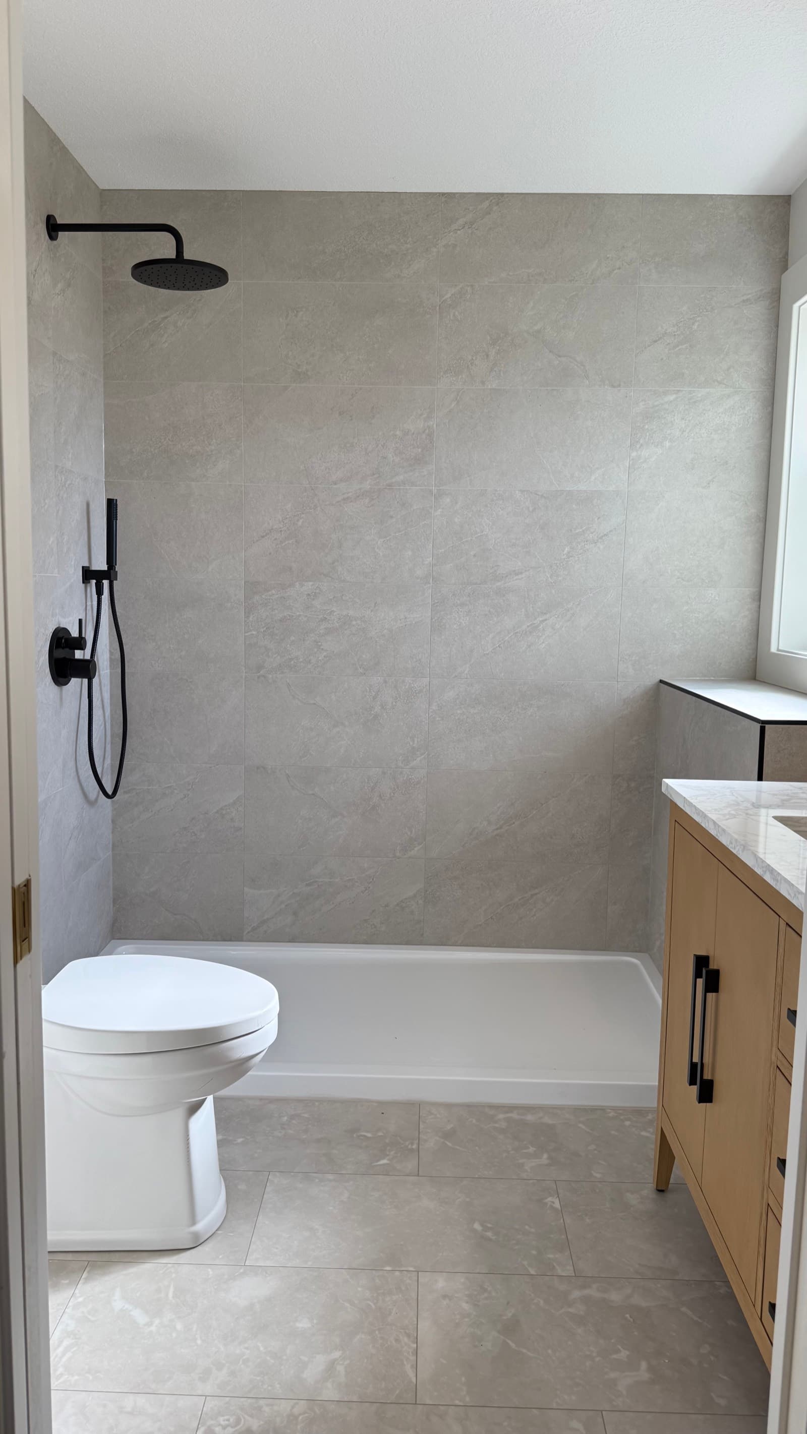 Completed Ladysmith bathroom with white oak vanity, honed marble and matte-black fixtures